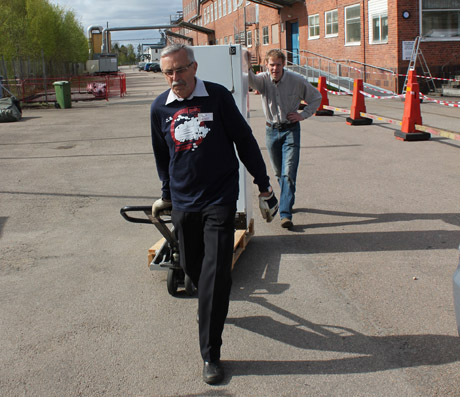Siwert och Tomas rullar ut kylsk&aring;pet till caf&eacute;t&auml;ltet. Kylen &auml;r l&aring;nad fr&aring;n gamla Ljungberga i Ljungby. Men kylsk&aring;pet m&aring;r bra.