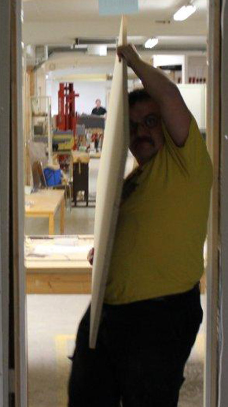 Oskar bar plywoodskivor mellan gamla nya lokalen, till nya nya lokalen.