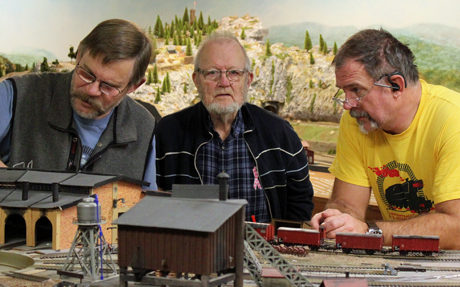 H&aring;kan plockar med n&aring;got. Hans pappa, Staffan, undrar vad och Bengt ser ut som en str&auml;ng rektor som tittar p&aring; ynglingen (H&aring;kan).