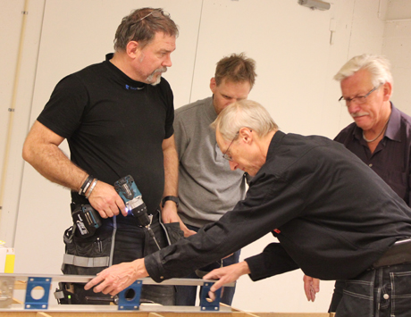 ...medan underredesg&auml;nget Bengt, Tomas Nyberg och &Aring;ke f&ouml;rordar vattenpass. Lasse f&ouml;rklarar f&ouml;r herrarna hur ett s&aring;dant funkar. Som "tack" f&ouml;r (dum)f&ouml;rklaringen borrar Bengt i Lasses arm.